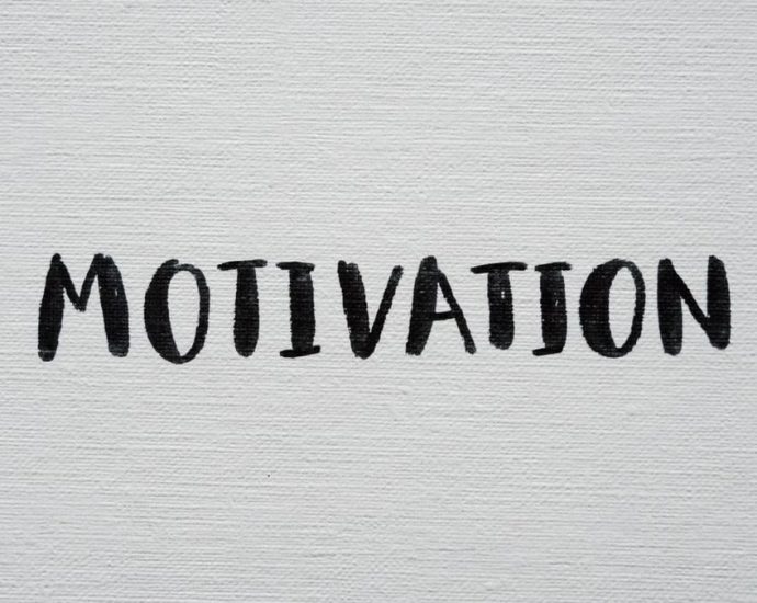 Inspirational word 'Motivation' in black on a white textured canvas background.
