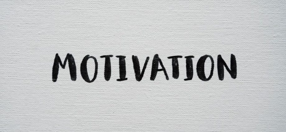 Inspirational word 'Motivation' in black on a white textured canvas background.